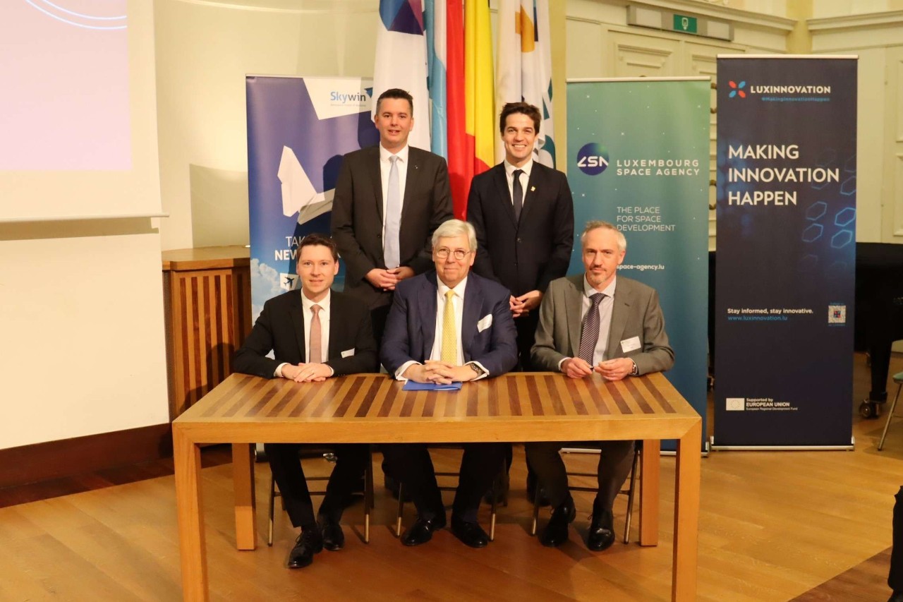 (assis, de g. à dr.) Philippe Osch, CEO de HITEC ; Yves Elsen, président du Conseil d’administration de HITEC ; Xavier Vérians, directeur commercial d’AMOS --- (derrière, de g. à dr.) Lex Delles, ministre de l’Économie, des PME, de l’Énergie et du Tourisme ; Thomas Dermine, secrétaire d’État pour la Relance et les Investissements stratégiques, chargé de la Politique scientifique, adjoint au ministre de l’Économie et du Travail du royaume de Belgique