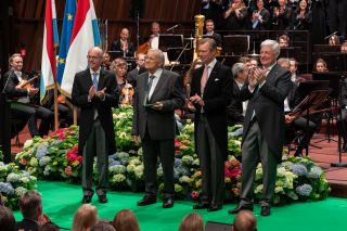 (v. l. n. r.) Luc Frieden, Premierminister; Pierre Cao, Dirigent a Museker; de Grand-Duc; Claude Wiseler, President vun der Chamber