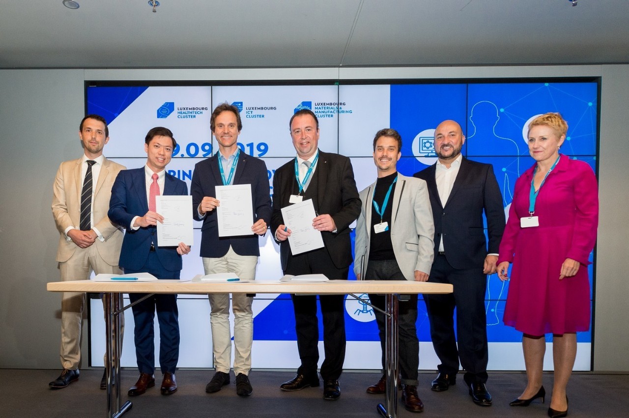 Tom Baumert, directeur de House of Entrepreneurship ; Raymond Moh, CEO de Hanalytics ; Dr Jean-Baptiste Niedercorn, représentant du groupe des radiologues des Hôpitaux Robert Schuman ; Dr Claude Schummer, directeur général des Hôpitaux Robert Schuman ; Dr Damien Dietrich, directeur médical de la digitalisation des Hôpitaux Robert Schuman ;  Étienne Schneider, Vice-Premier ministre, ministre de l'Économie et ministre de la Santé, et Sasha Baillie, CEO de Luxinnovation, lors de la signature d'un partenariat dans le domaine de l'analyse d'images radiologiques basée sur l'intelligence artificielle